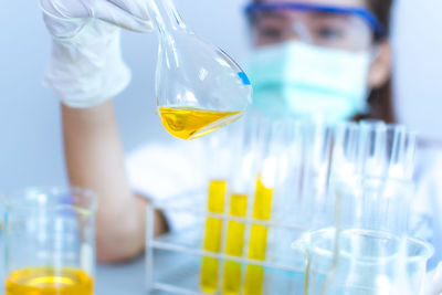 Scientist examining yellow chemical in laboratory