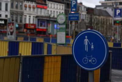 Close-up of road sign against buildings in city