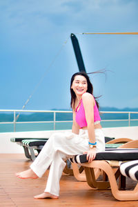 Portrait of young woman sitting at beach