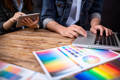 Midsection of man using mobile phone on table