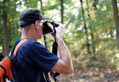 Man photographing in forest