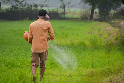 Rear view of man walking on field