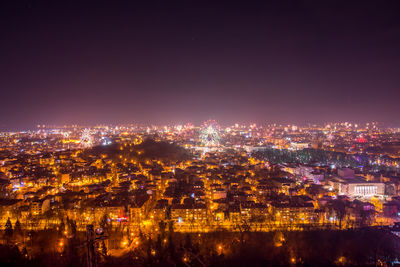 Illuminated cityscape against sky at night