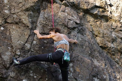 Low angle view of woman climbing on mountain