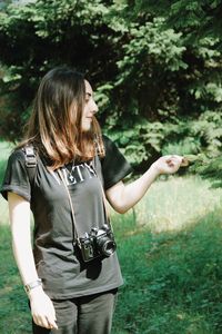 Woman standing by tree on field