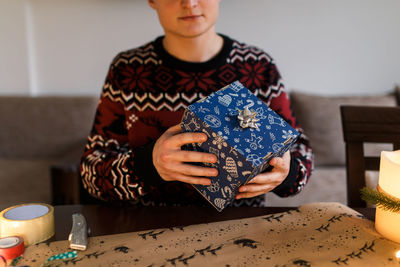 Young man packs christmas presents for friends and family