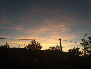 Low angle view of silhouette trees against sky