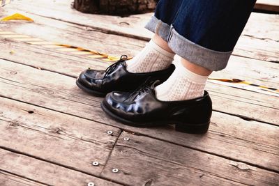 Low section of boy standing on wooden surface