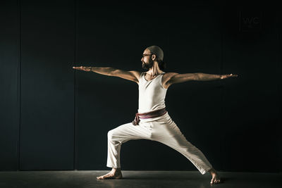 Full length of young man standing against black background