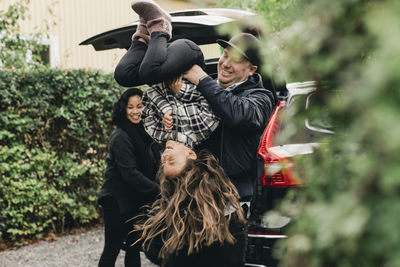 Playful father lifting daughter upside down