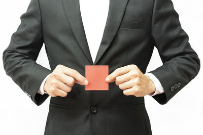 Midsection of man holding hands against white background