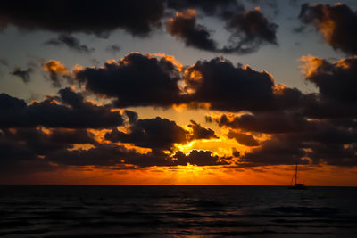 Scenic view of sea against dramatic sky during sunset