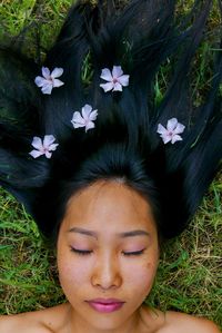 Close-up of woman with eyes closed lying on land in park