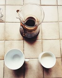 Close-up of coffee cups on tiled floor