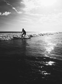 Silhouette person on beach against sky