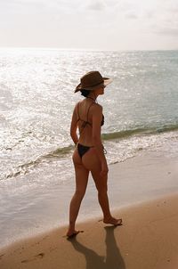 Rear view of woman standing at beach