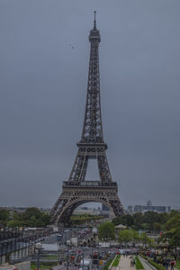 Communications tower in city against sky