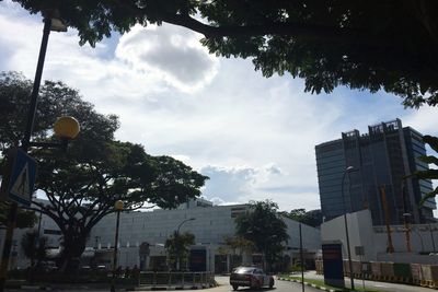 Traffic on road against cloudy sky