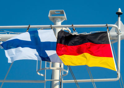 Low angle view of flag against blue sky