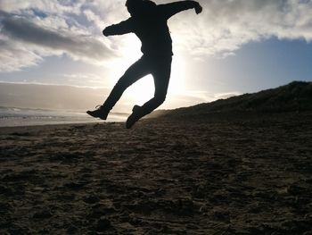 Silhouette of man jumping at sunset