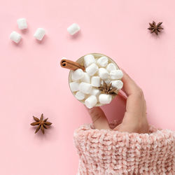 Winter drink, mug with marshmallows in hand in sweater. top view. christmas festive decor. xmas.
