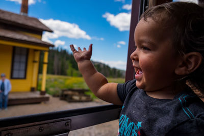 Cute baby boy against sky