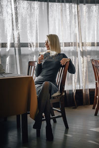 Woman sitting on chair at home