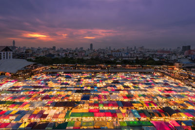 High angle view of illuminated city against sky at sunset