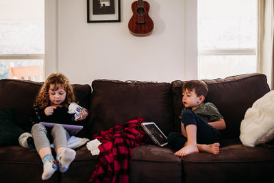 Young sister and brother home sick from school with flu