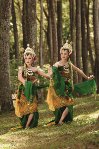 Women in traditional clothing dancing at forest