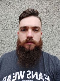 Portrait of man standing against wall