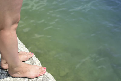Low section of man standing in lake