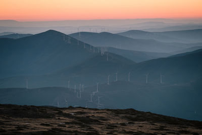 High angle view of windmills on mountains against sky during sunset