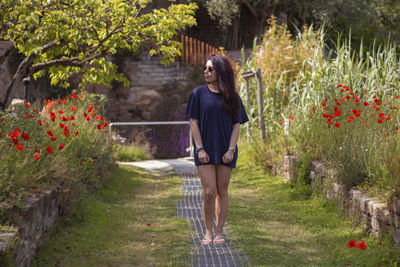 Rear view of woman walking on flowering plants