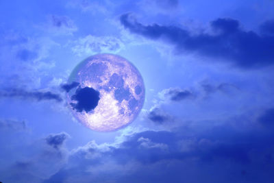 Low angle view of moon against blue sky