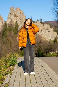 Portrait of a girl in a jacket on a mountain background.