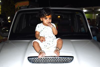 Portrait of smiling cute baby sitting on car