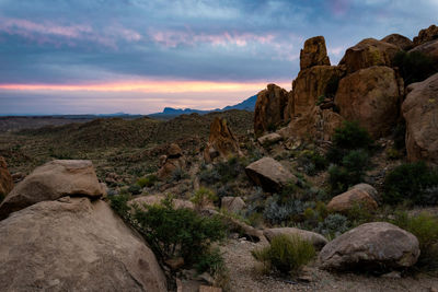 Rock formations on landscape against sky during sunset