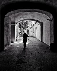 Rear view of silhouette man walking in tunnel