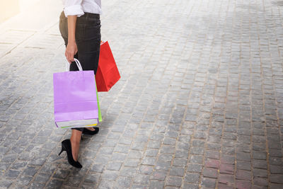 Low section of woman walking on sidewalk