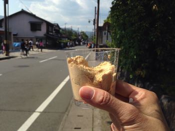 Close-up of person holding ice cream cone on street