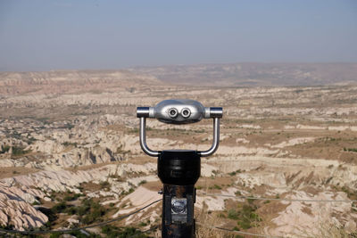 Close-up of coin-operated binoculars against landscape