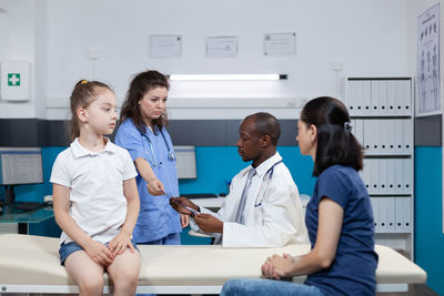 Doctors examining patient in clinic