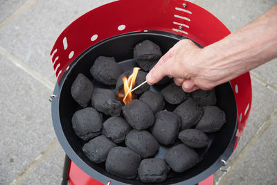 A man lights a fire with a lighter special charcoals for a barbecue