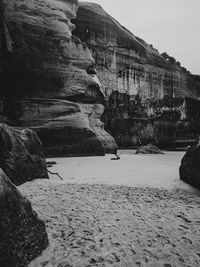 Rock formations on beach against sky