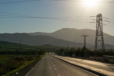 Road by mountains against sky