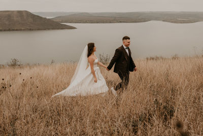 Rear view of couple standing on field