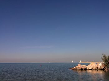 Scenic view of sea against clear blue sky