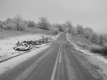 Road amidst trees against sky