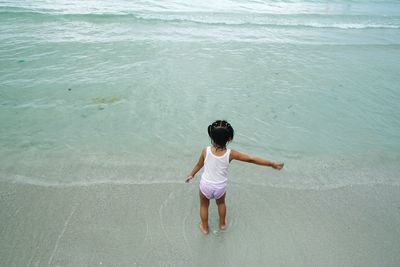 Rear view of girl standing on beach